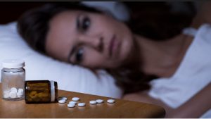 Why did my sleeping pills stop working older woman lying awake in bed staring at sleeping pills during insomnia